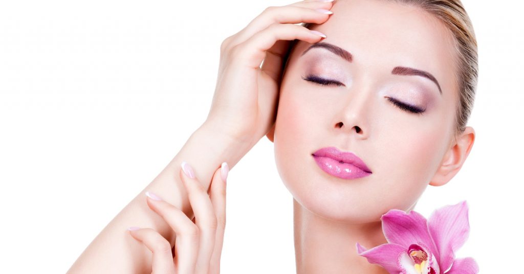 beautiful girl with flower near face isolated white wall