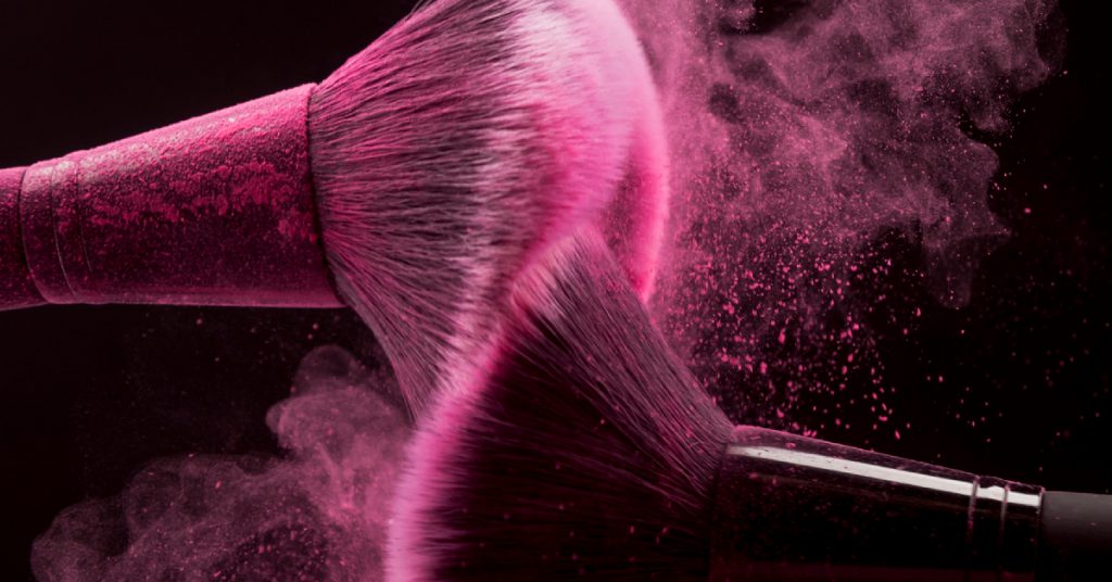 makeup brushes with pink powder splash