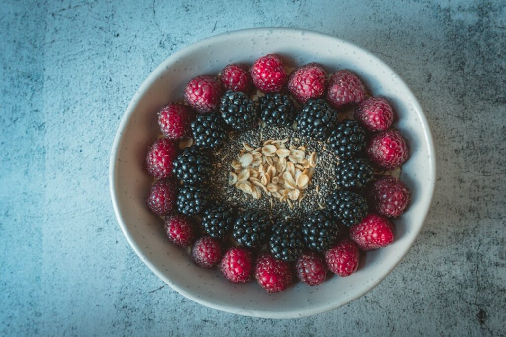 A bowl of oats with raspberries and blackberries