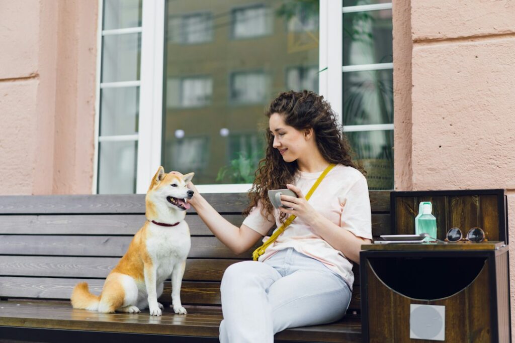 A woman stroking a dog outside a cafe