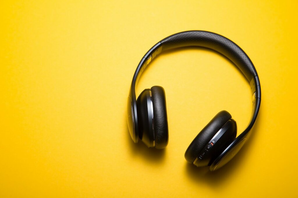 Black over-ear headphones on a yellow surface
