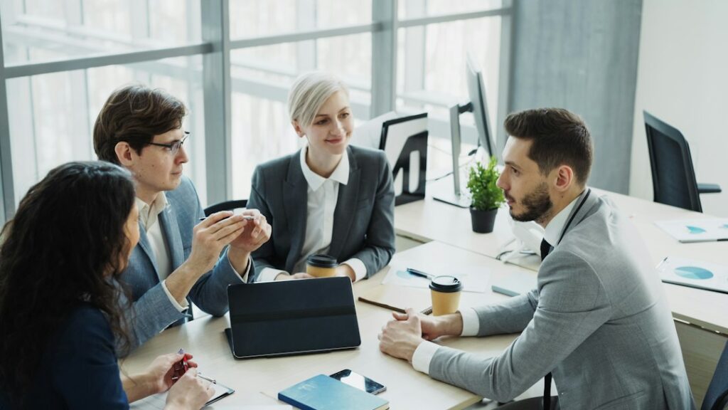 Colleagues discussing a project around an office table