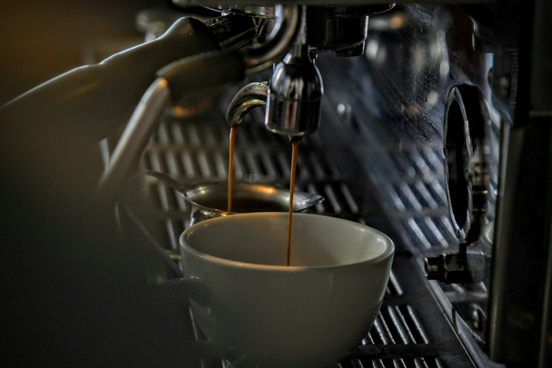 Espresso pouring from a coffee machine into a cup