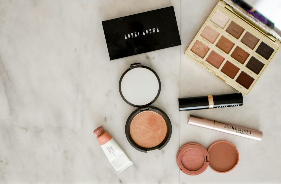 Eyeshadow palettes, blush and makeup arranged on a light surface