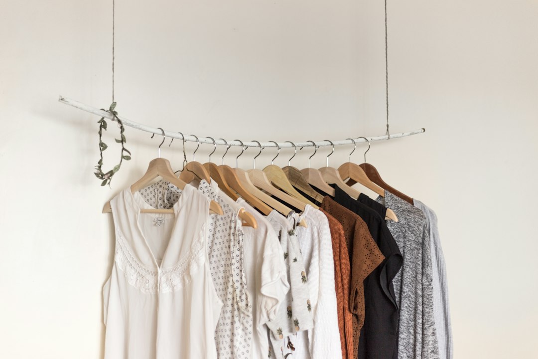 Neutral shirts and dresses on wooden hangers