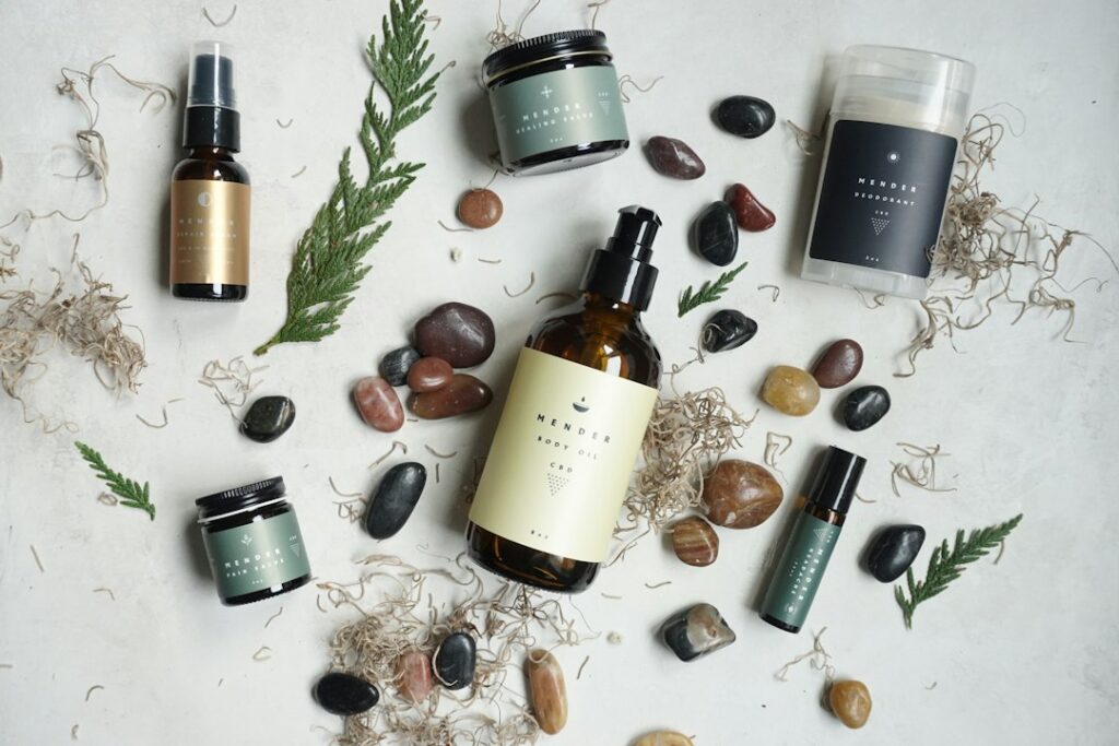 Skincare bottles arranged with stones and green sprigs