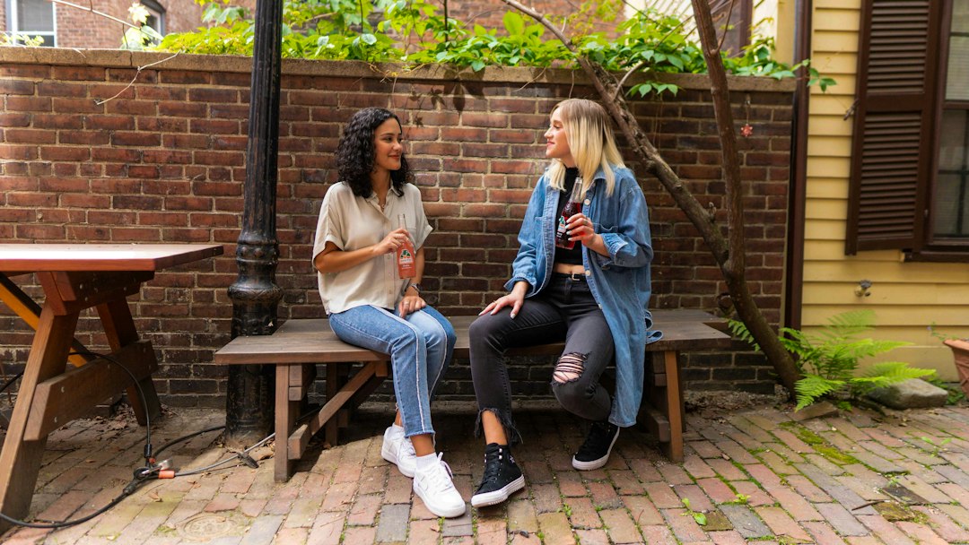 Two friends talking on a bench outdoors