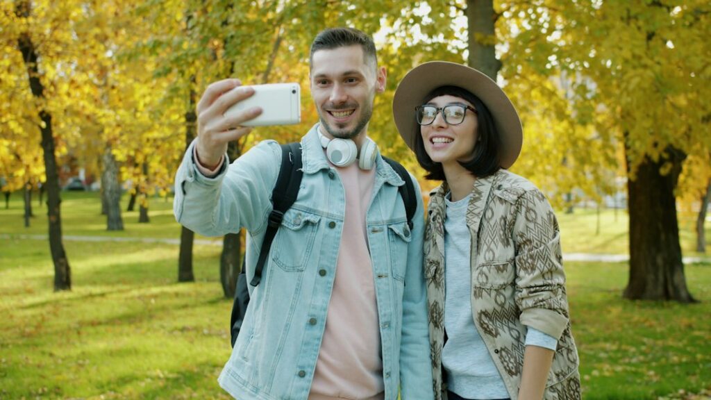 Two people making a video call in a leafy park